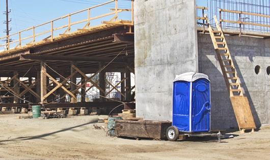 portable toilets set up for workers’ use at a busy construction site